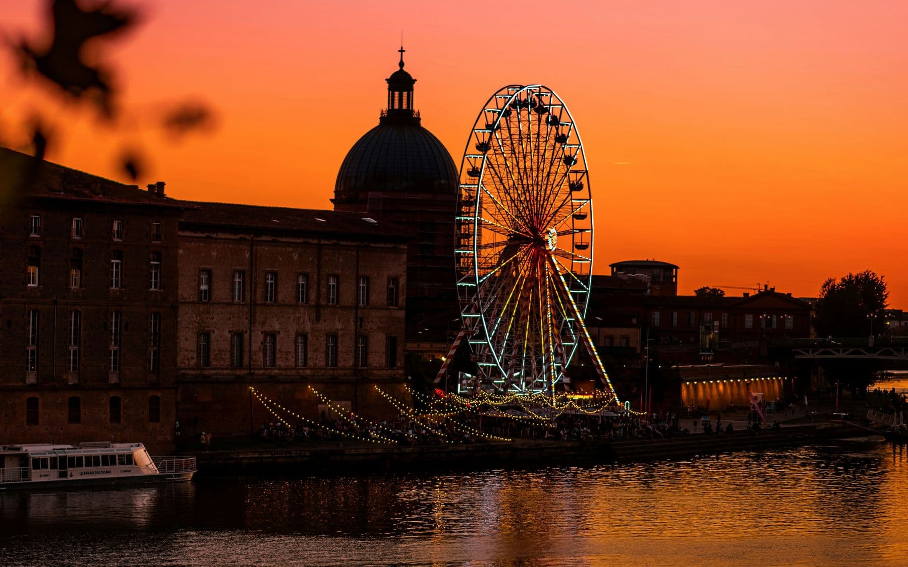 Le dôme de la Grave et la grande roue au coucher du soleil, sur les bords de la Garonne